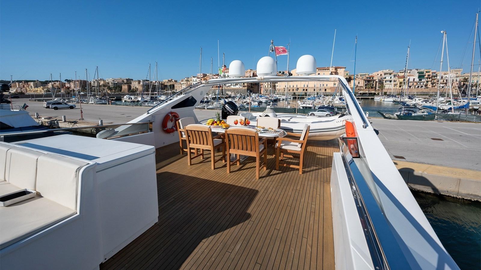 a deck with a table and chairs on it aboard FIRST LADY II Yacht for Sale