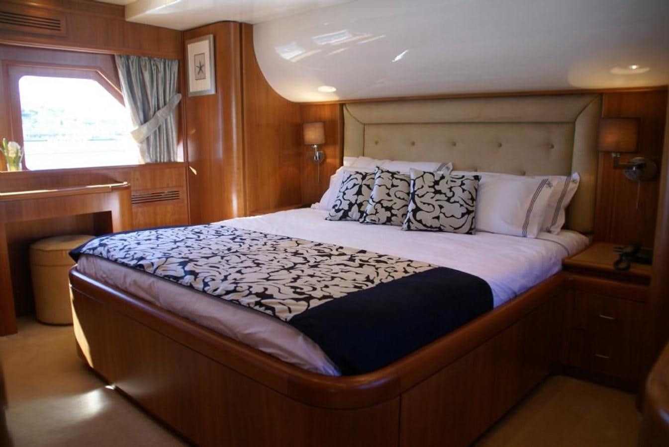 a bed with a blue and white comforter and pillows aboard AMANZI Yacht for Sale