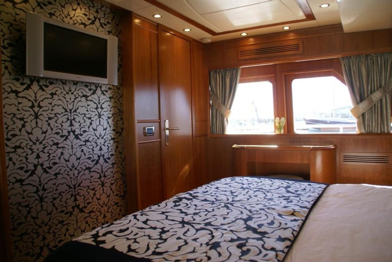 a bedroom with a bed and a television aboard AMANZI Yacht for Sale