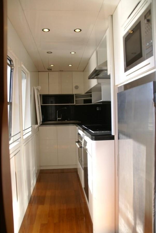 a kitchen with white cabinets aboard AMANZI Yacht for Sale