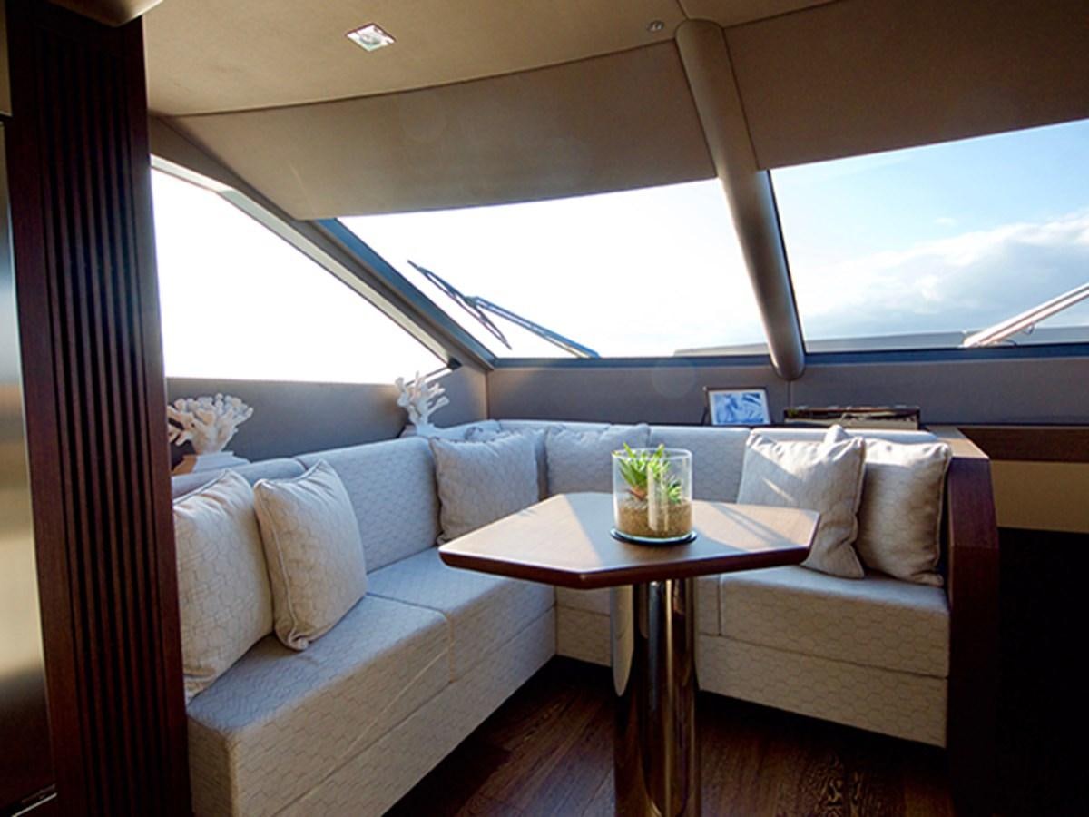 a couch with a table and a coffee table in front of a window aboard LADY O Yacht for Sale