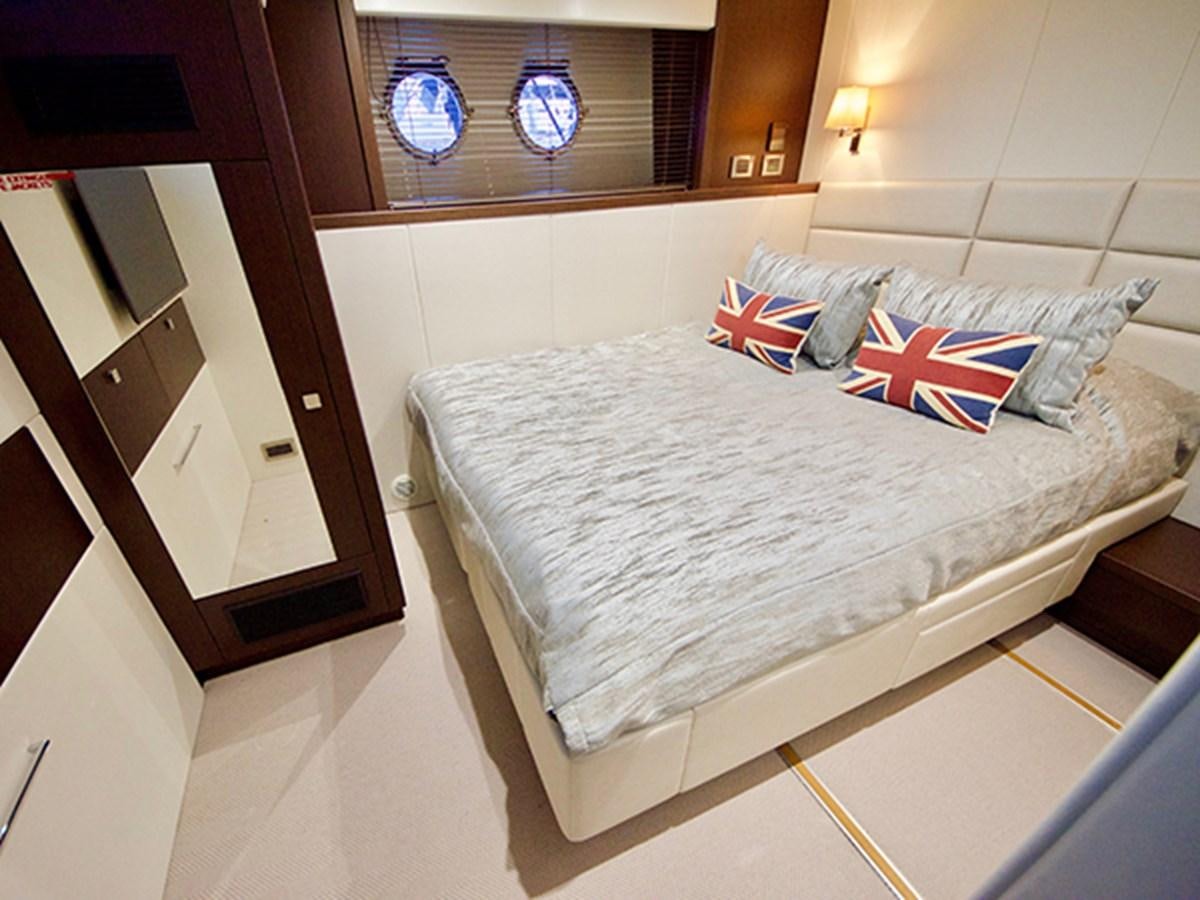 a bed with a white sheet and blue and red pillows aboard LADY O Yacht for Sale