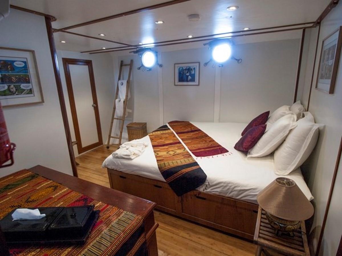 a bedroom with a bed and a table aboard KAMA BAY Yacht for Sale