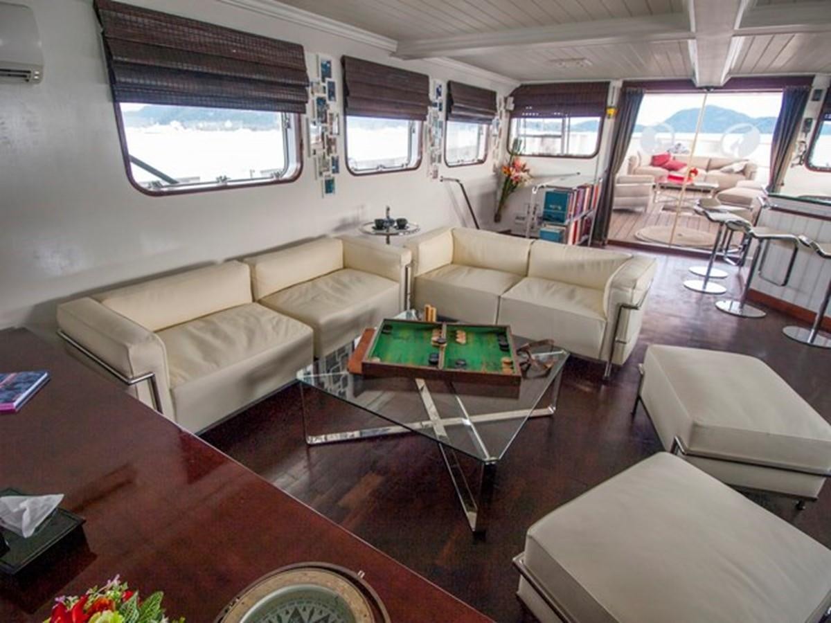 a living room with a table and couches aboard KAMA BAY Yacht for Sale