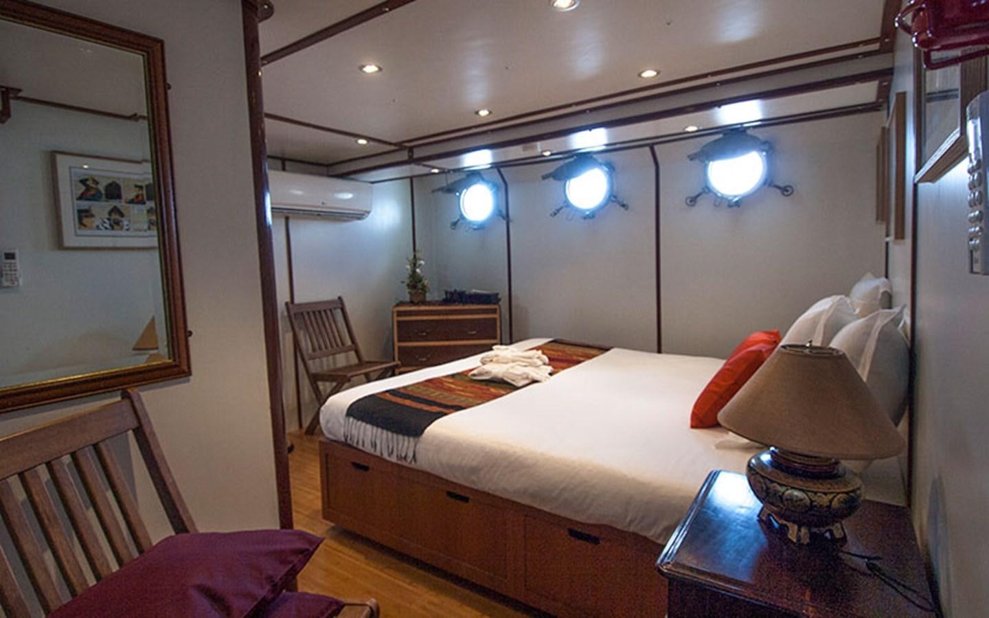 a bedroom with a bed and a lamp aboard KAMA BAY Yacht for Sale