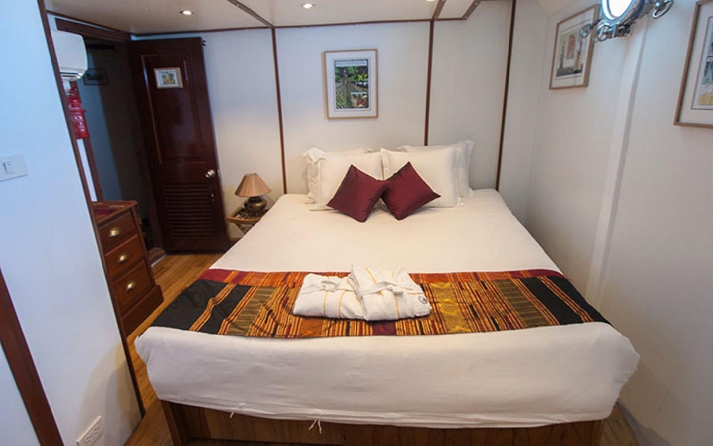a bed with white sheets aboard KAMA BAY Yacht for Sale