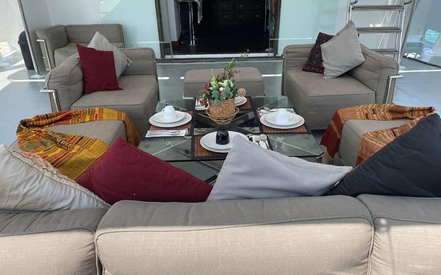 a living room with a couch and a coffee table aboard KAMA BAY Yacht for Sale