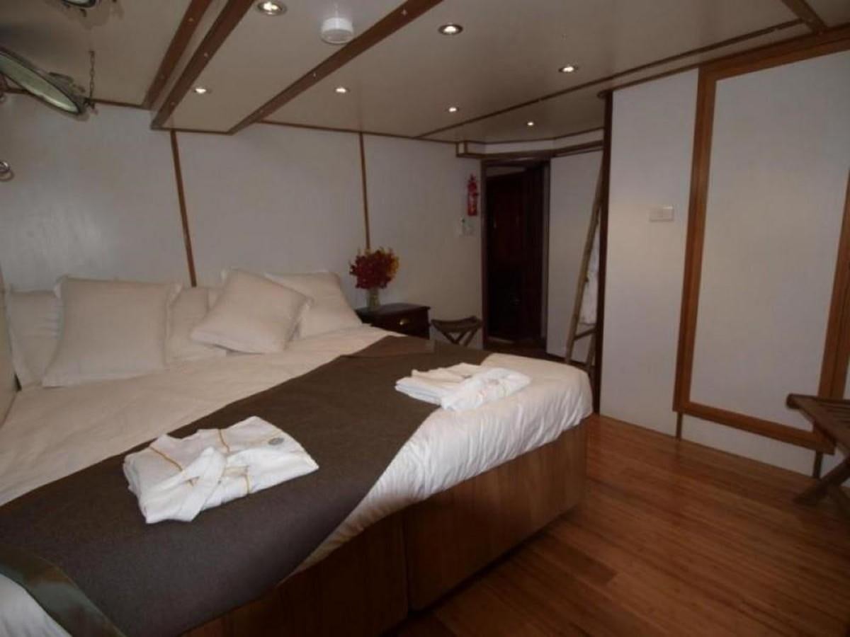a bed with white sheets aboard KAMA BAY Yacht for Sale