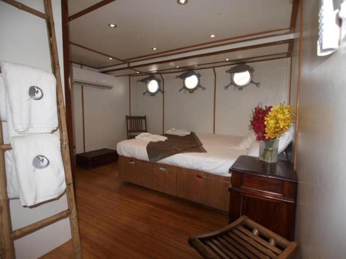 a bedroom with a bed and a table aboard KAMA BAY Yacht for Sale