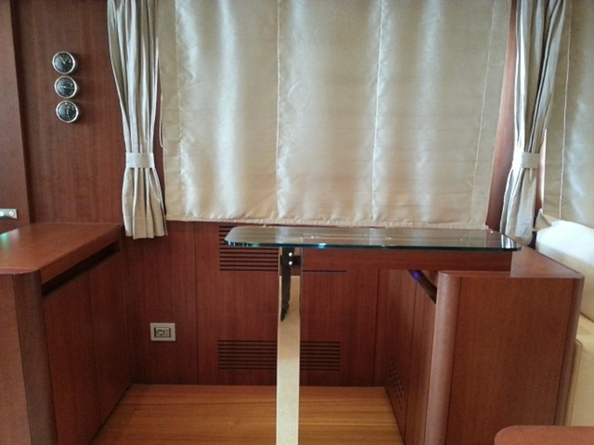 a kitchen with a wood table and a white curtain aboard MY JAYA Yacht for Sale