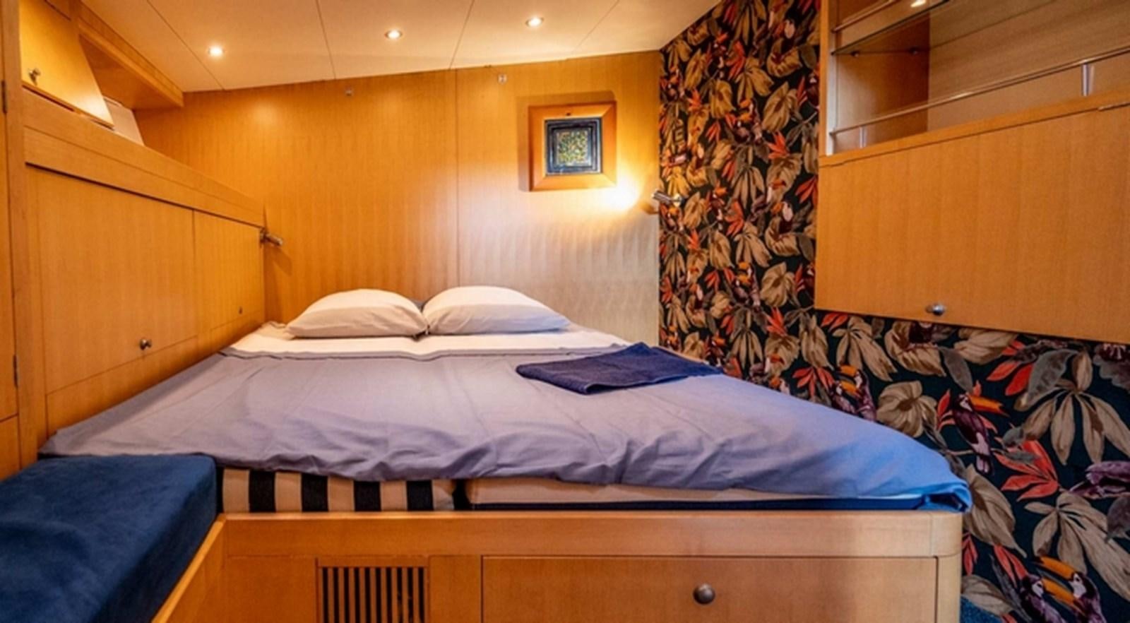 a bed with a blue sheet aboard FANI Yacht for Sale