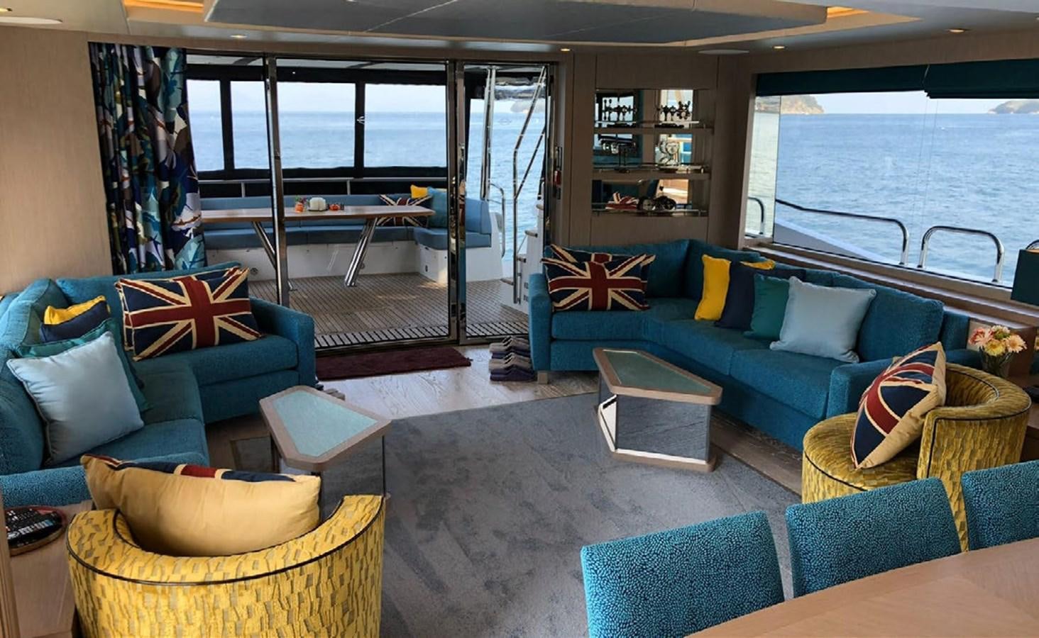 a living room with a blue couch and a table aboard SKYE Yacht for Sale