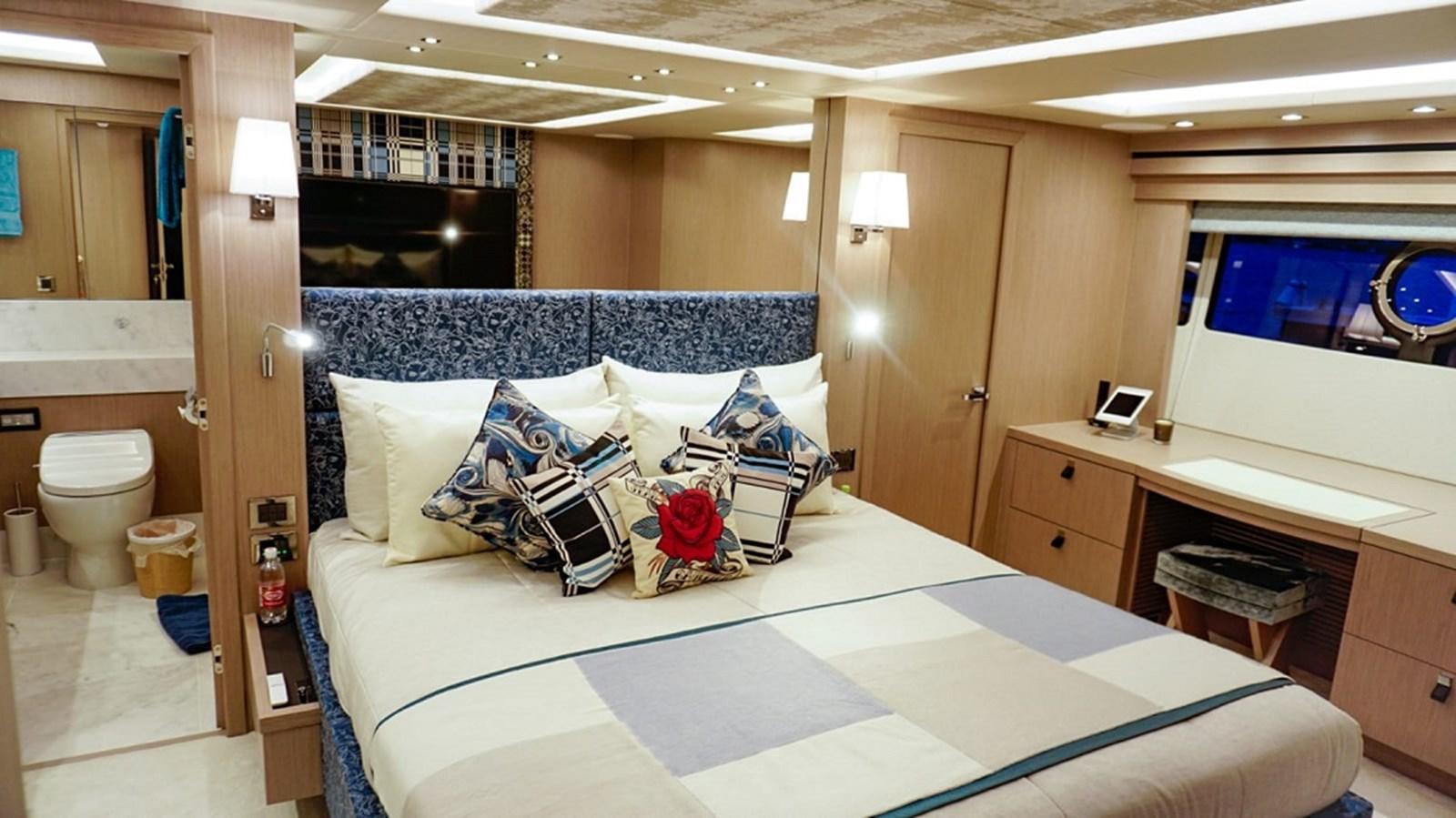 a bedroom with a bed and desk aboard SKYE Yacht for Sale