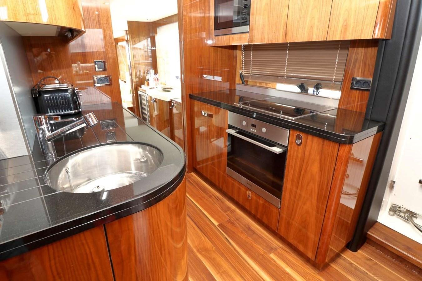 a kitchen with wooden cabinets aboard SUNSEEKER 86 Yacht for Sale