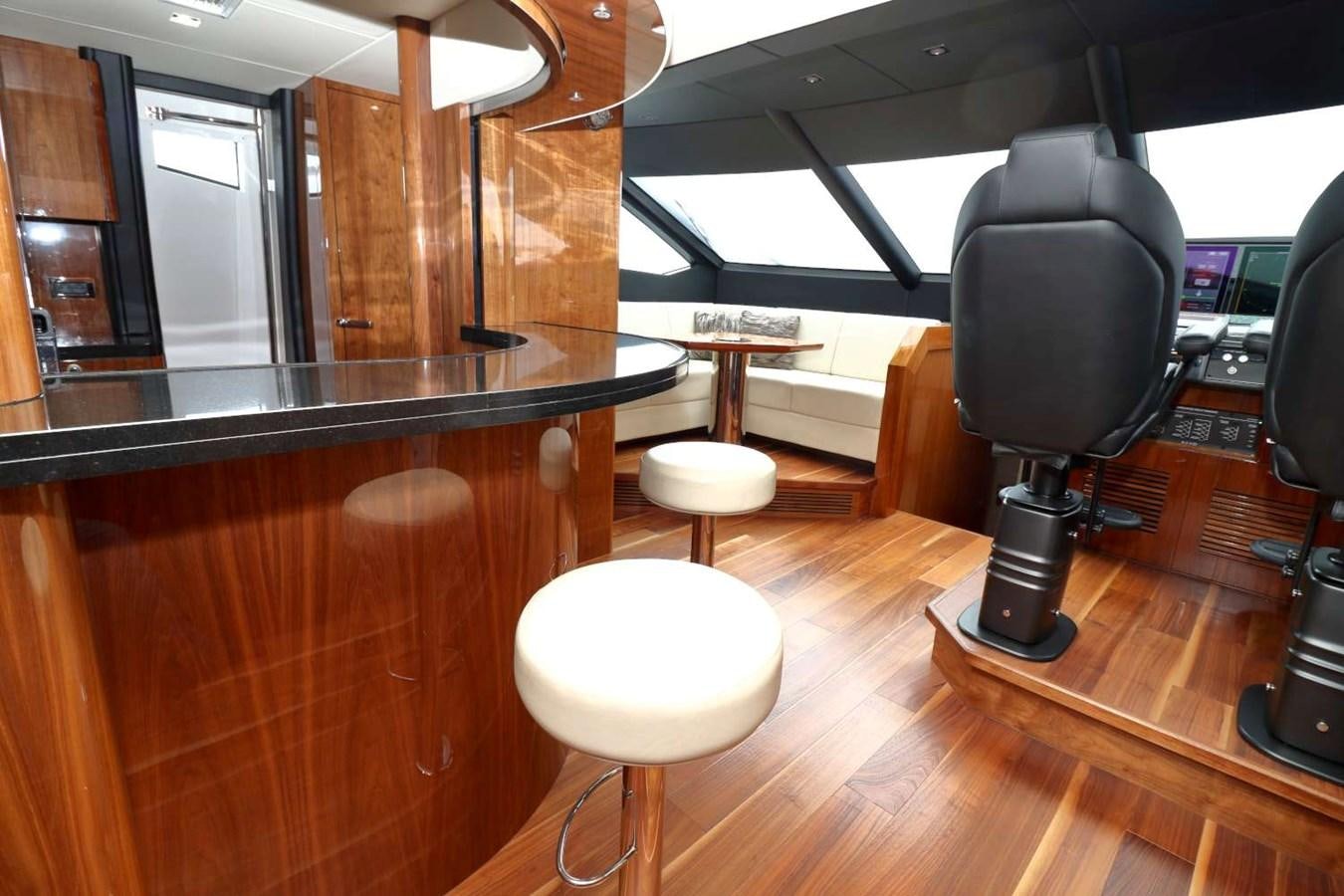 a room with a bar and stools aboard SUNSEEKER 86 Yacht for Sale