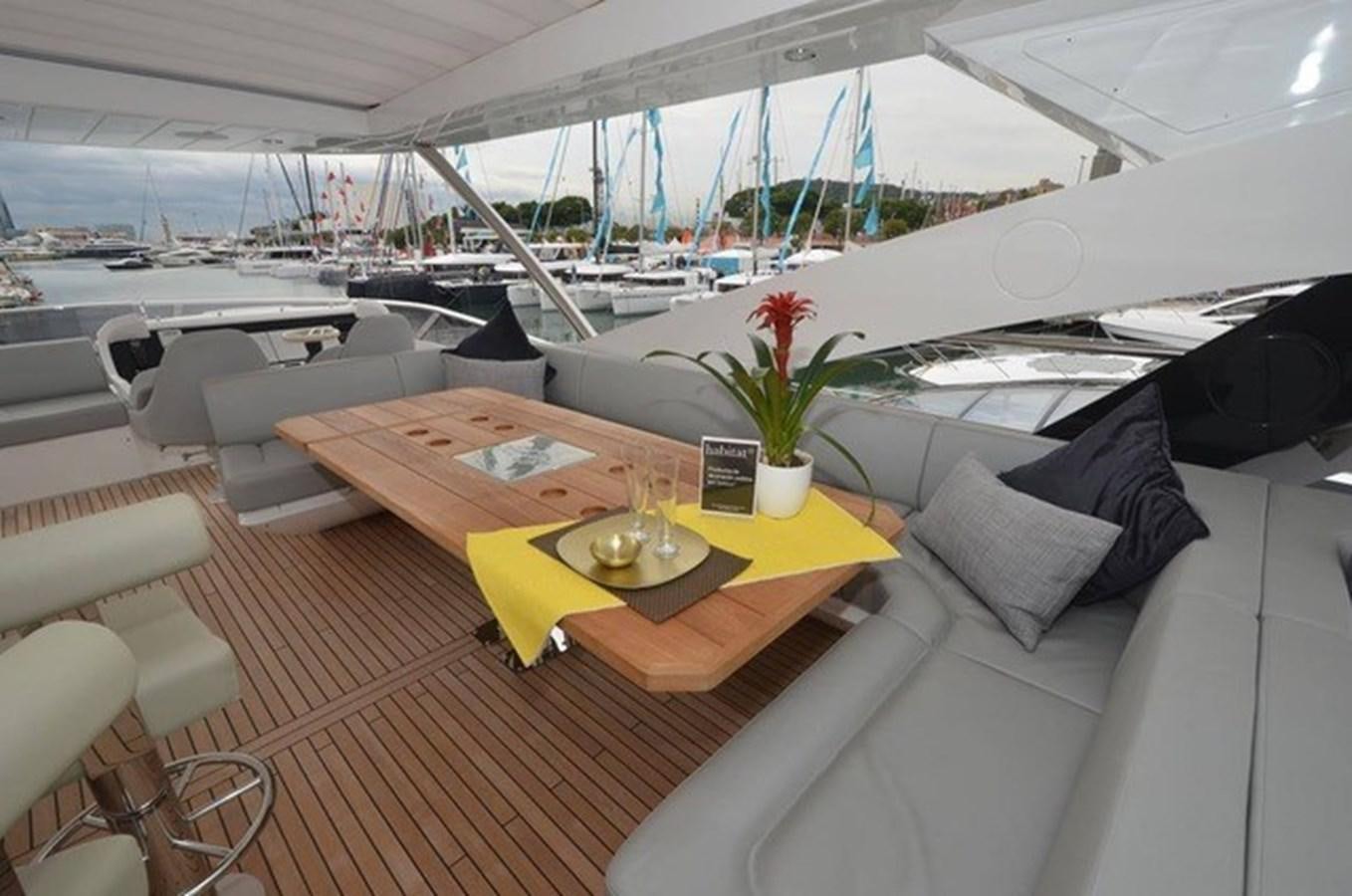 a table with chairs and a boat in the background aboard SUNSEEKER 86 Yacht for Sale