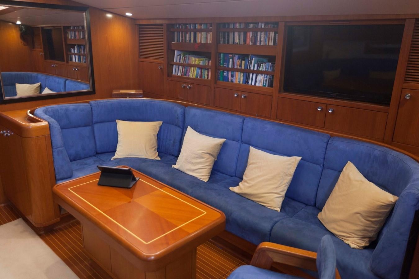 a couch with pillows and a coffee table in a room with a tv aboard DREAMLAND Yacht for Sale