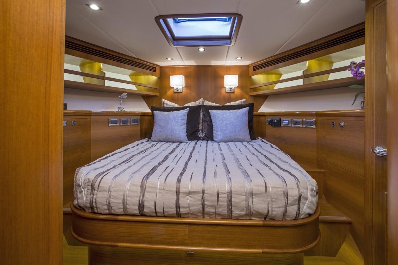 a bed with a blue and white striped bed spread aboard 860 DBMY Yacht for Sale