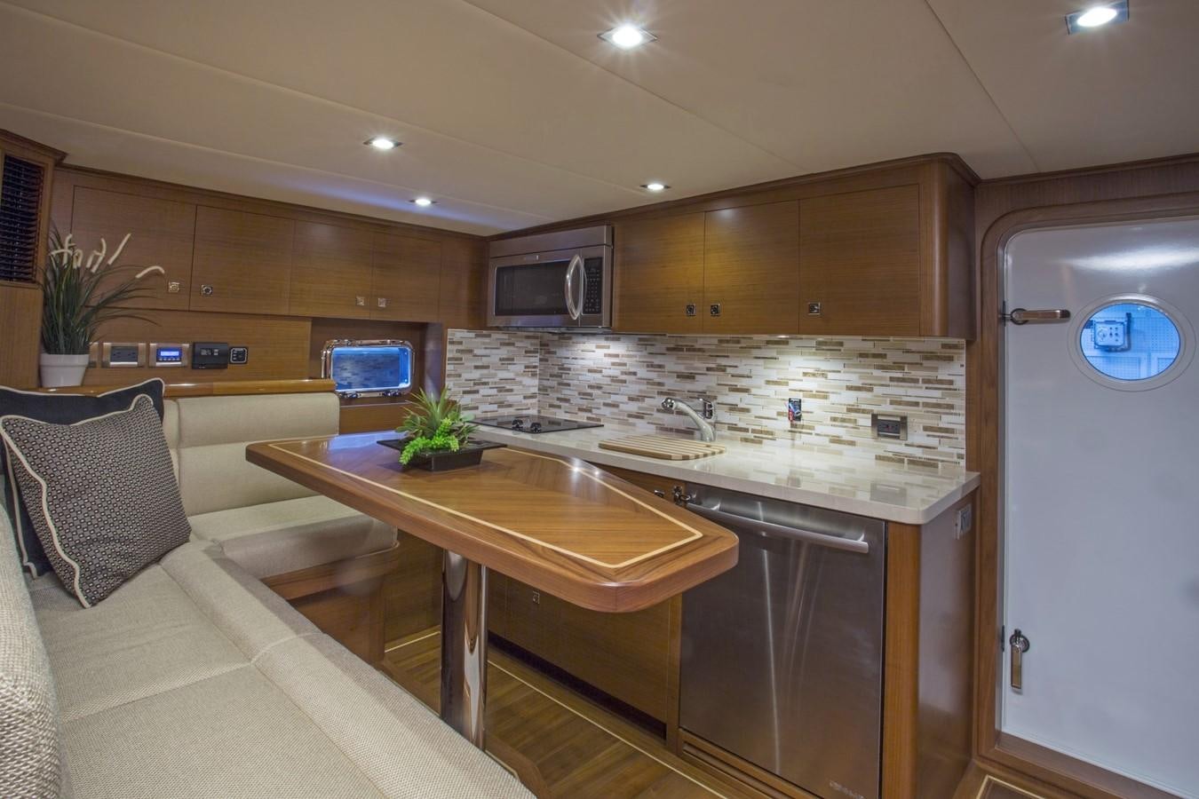 a kitchen with a table and couch aboard 860 DBMY Yacht for Sale
