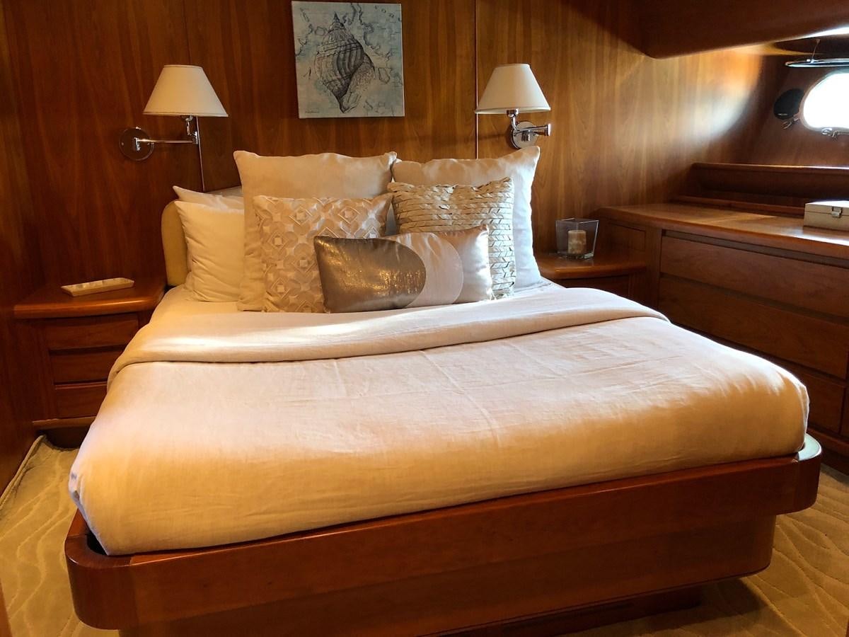 a bed with a wooden headboard aboard CATARI Yacht for Sale