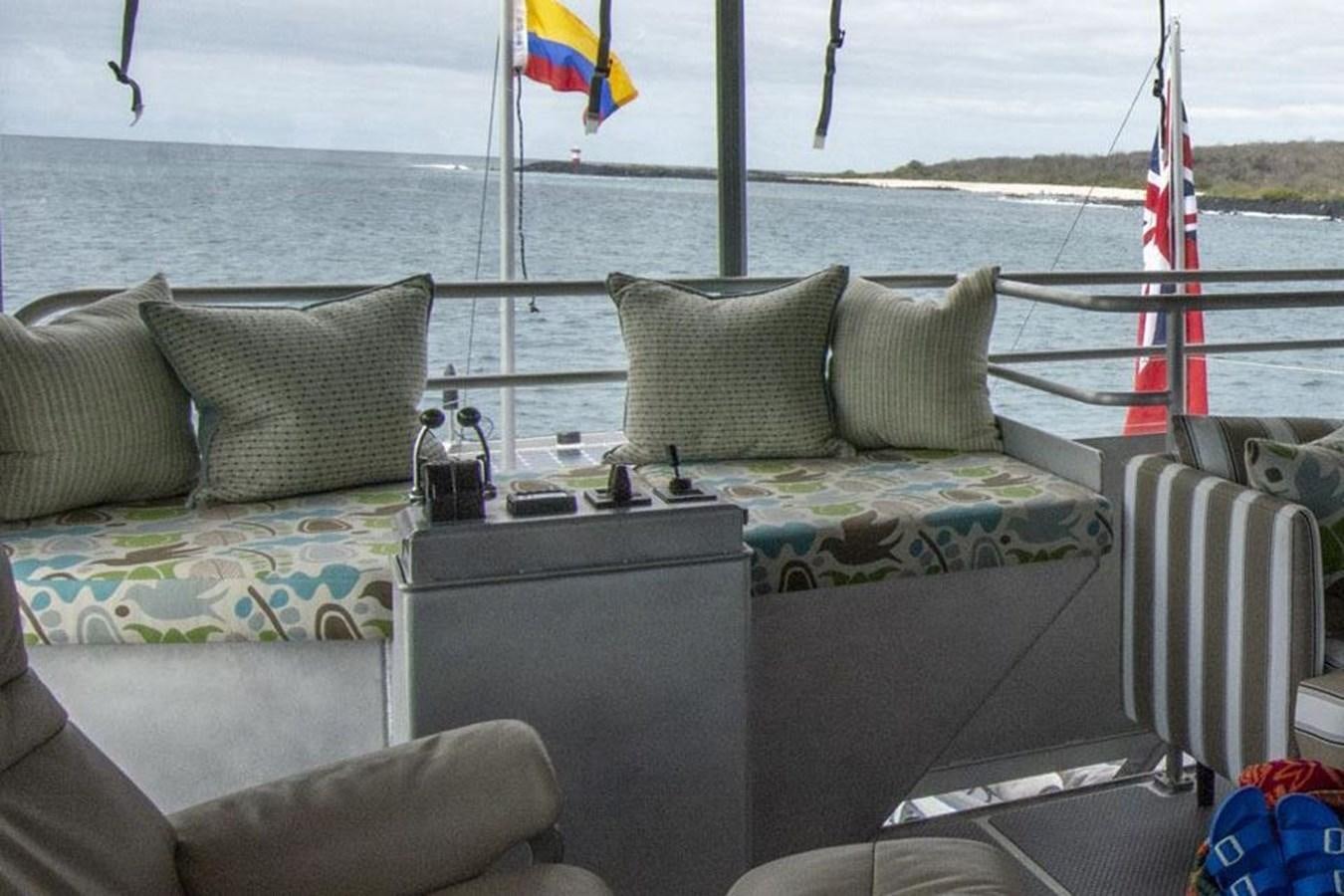 a couch with pillows on it by a body of water aboard IRON LADY II Yacht for Sale