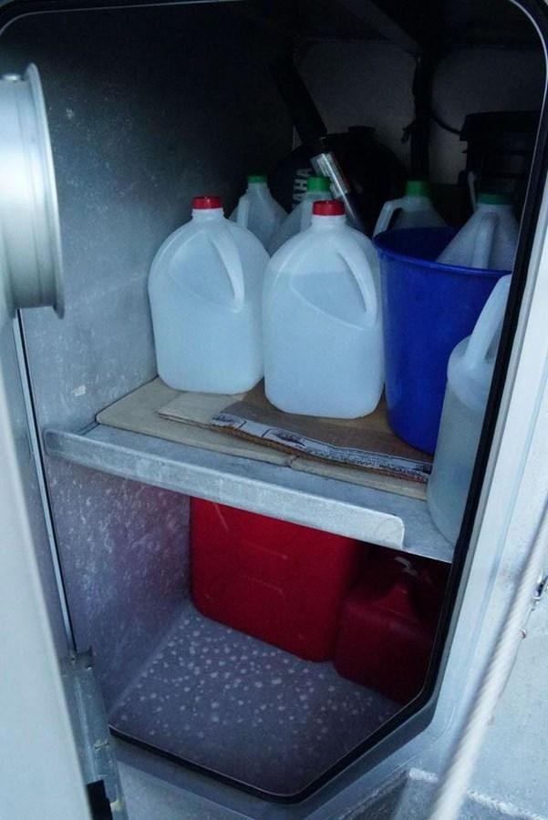 a plastic bottle and a plastic cup on a shelf aboard IRON LADY II Yacht for Sale