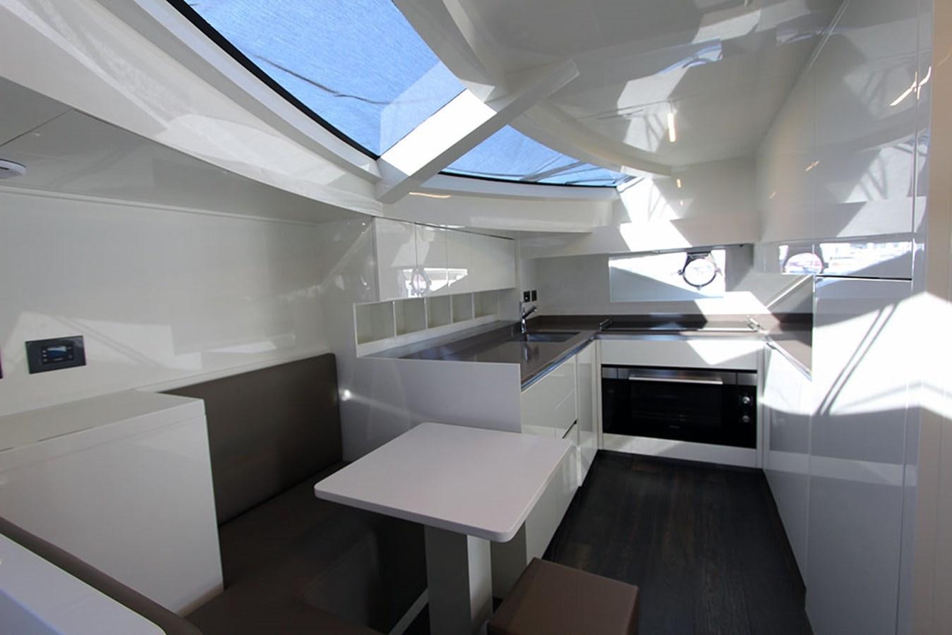 a room with white walls and a black table and white chairs aboard ANASSA A Yacht for Sale