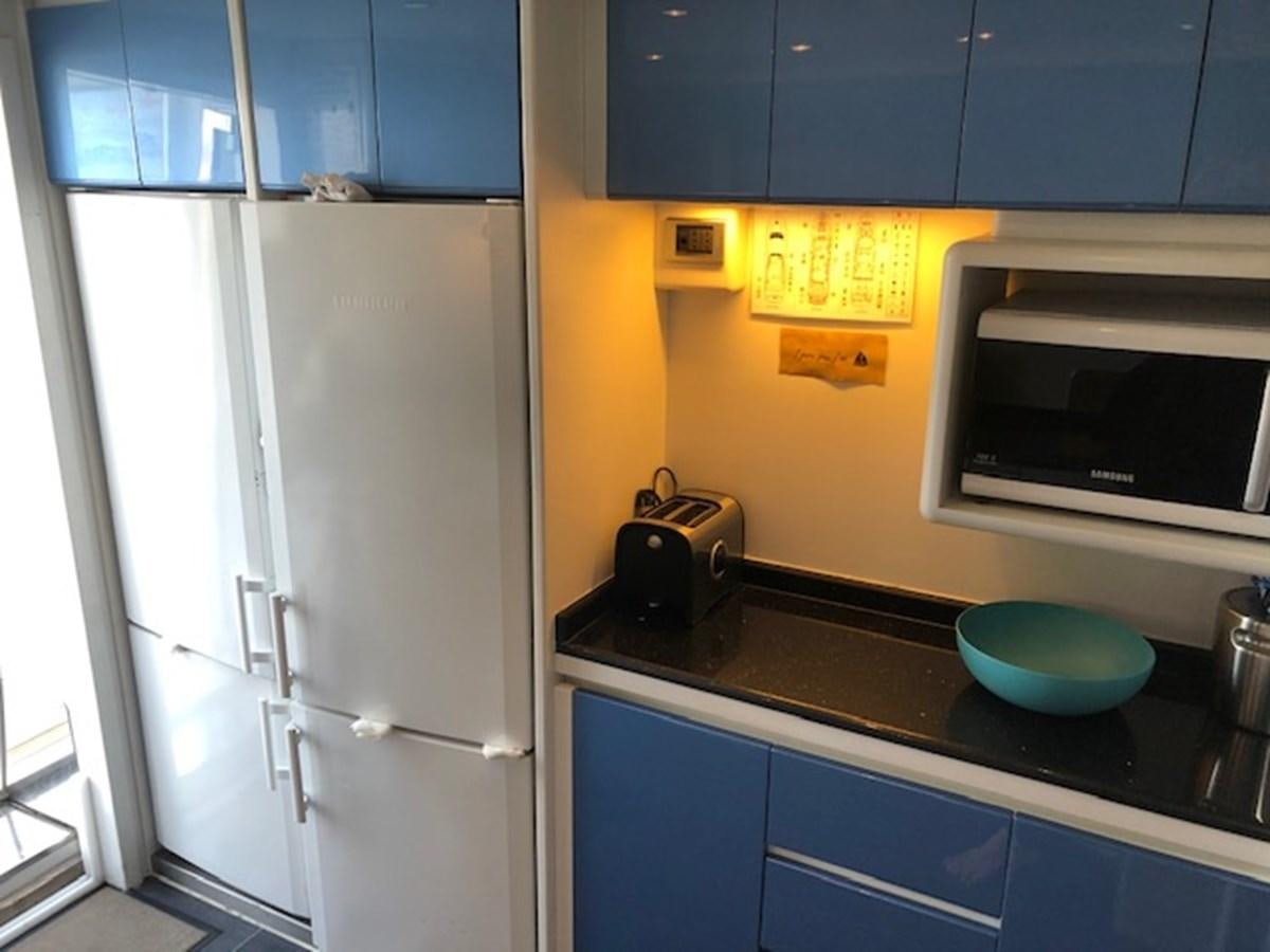 a kitchen with blue cabinets aboard BARON B Yacht for Sale