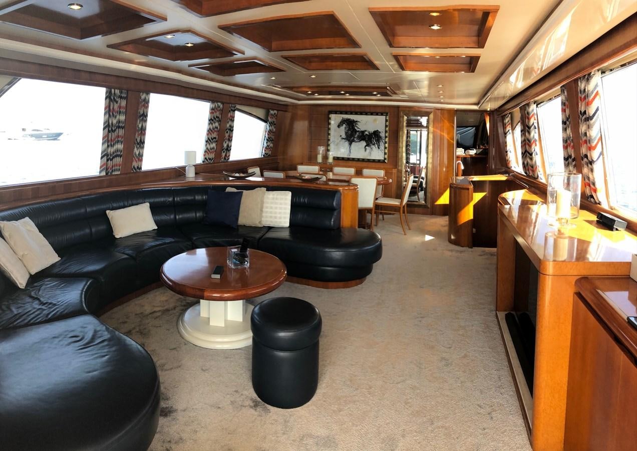 a living room with a black couch and a black leather couch aboard BARON B Yacht for Sale