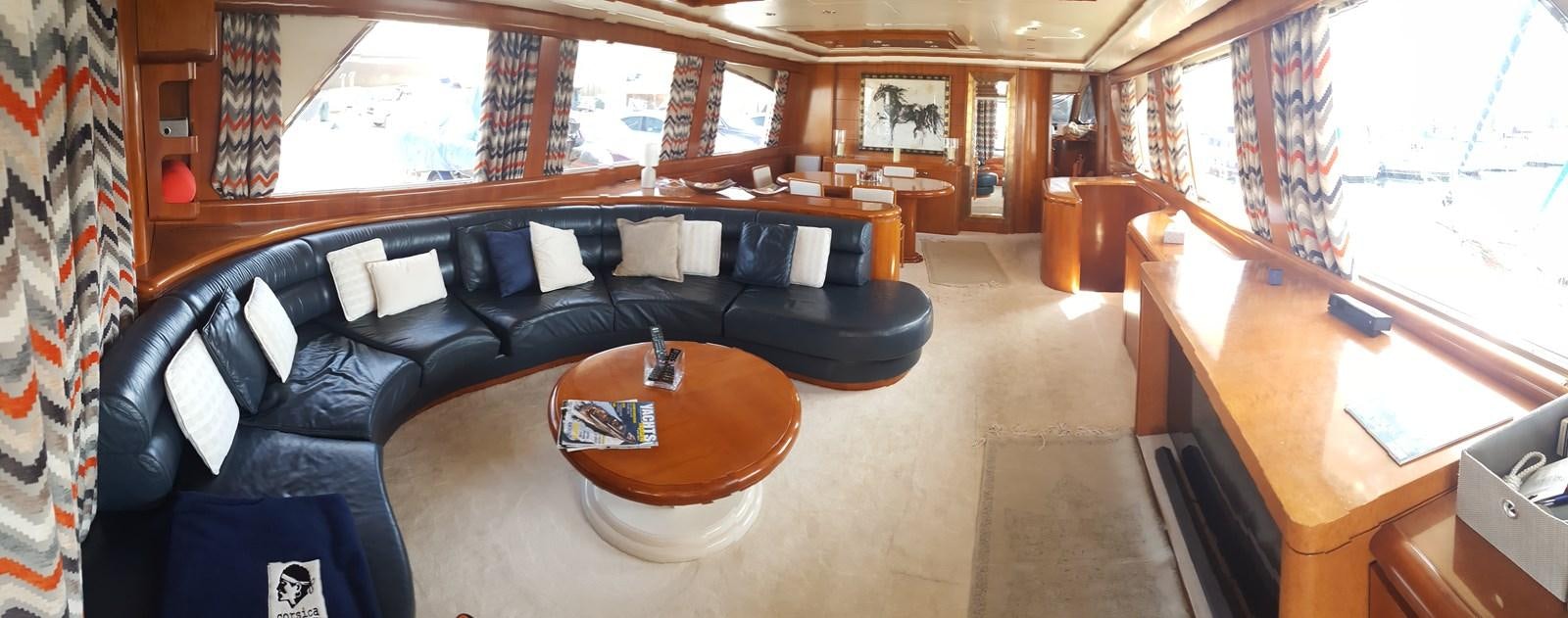 a living room with a black couch and a table aboard BARON B Yacht for Sale