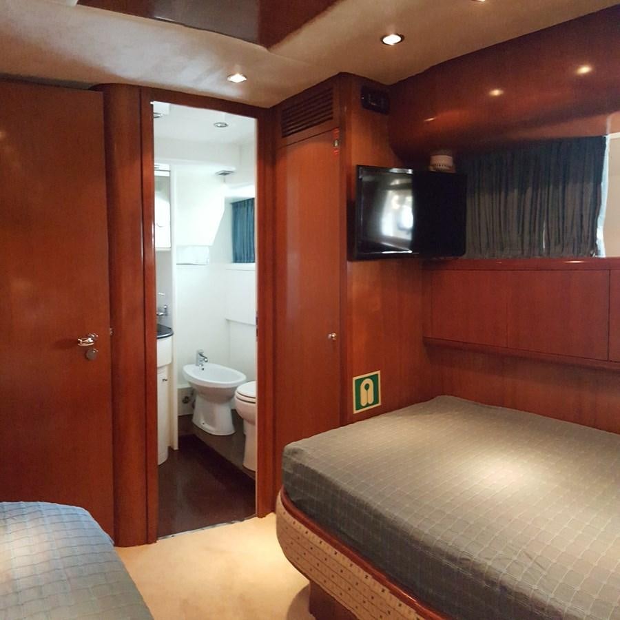 a bedroom with a bed and a television aboard BARON B Yacht for Sale