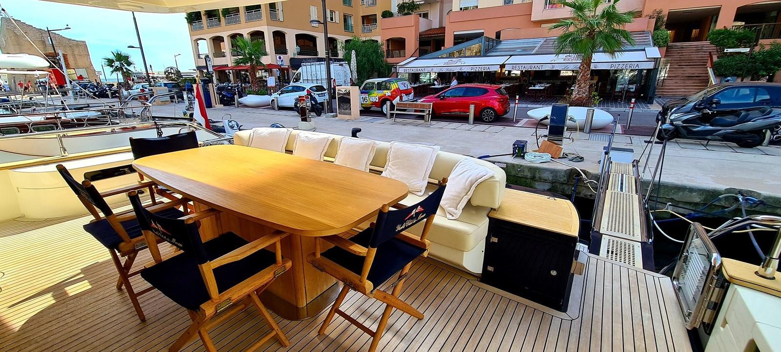 a deck with chairs and tables on it aboard RITAKI 7 Yacht for Sale