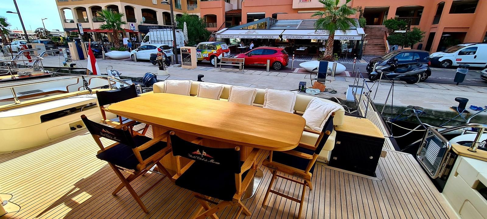 a table and chairs on a deck aboard RITAKI 7 Yacht for Sale