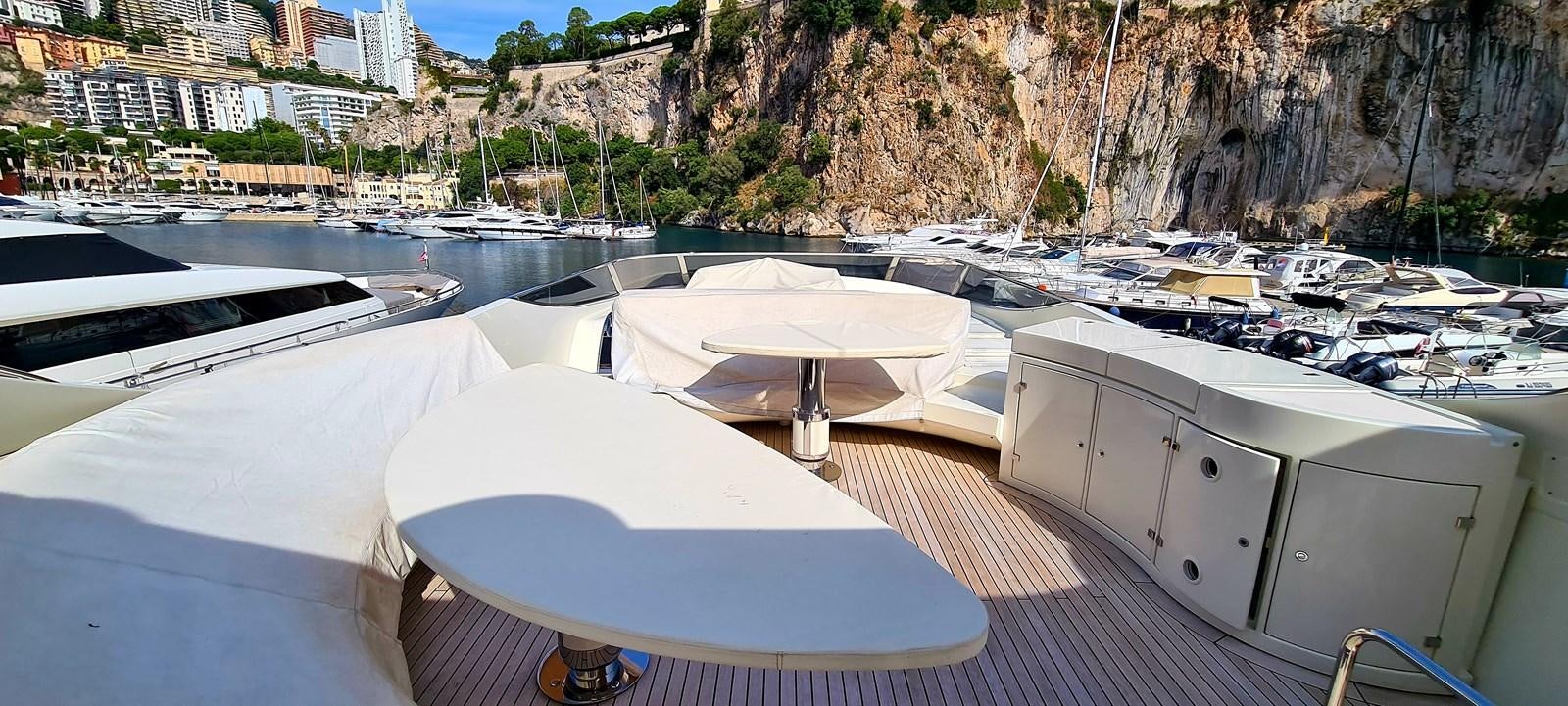 a deck with a boat and a city in the background aboard RITAKI 7 Yacht for Sale