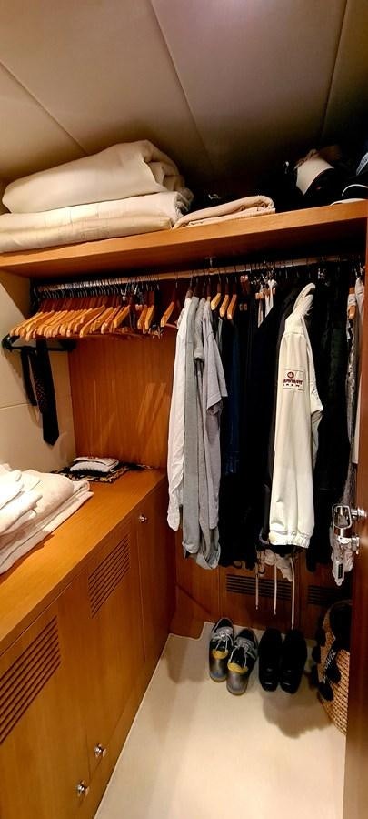 a closet with clothes and shoes aboard RITAKI 7 Yacht for Sale