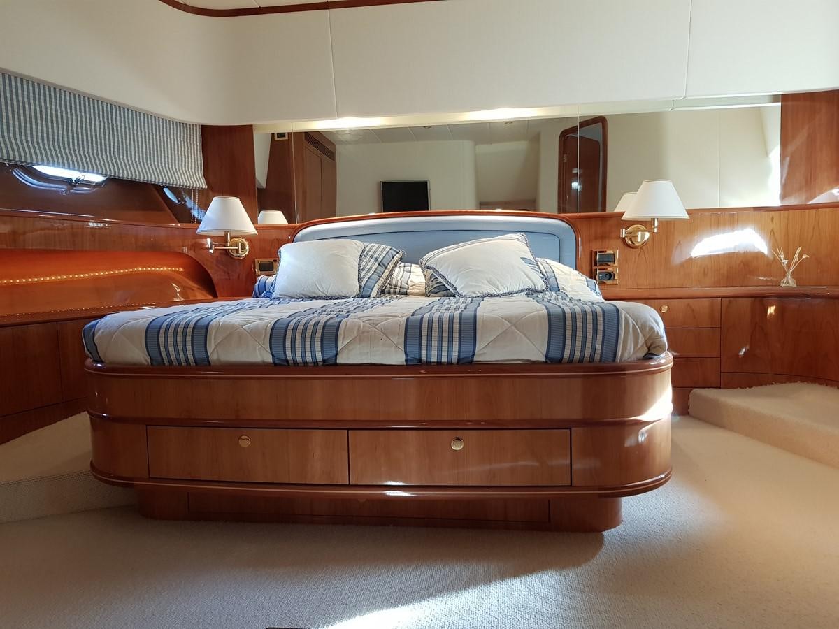 a bed with blue and white sheets aboard BLUE DEEP Yacht for Sale