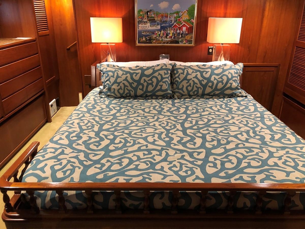 a bed with a blue comforter aboard GOLDEN EAGLE Yacht for Sale