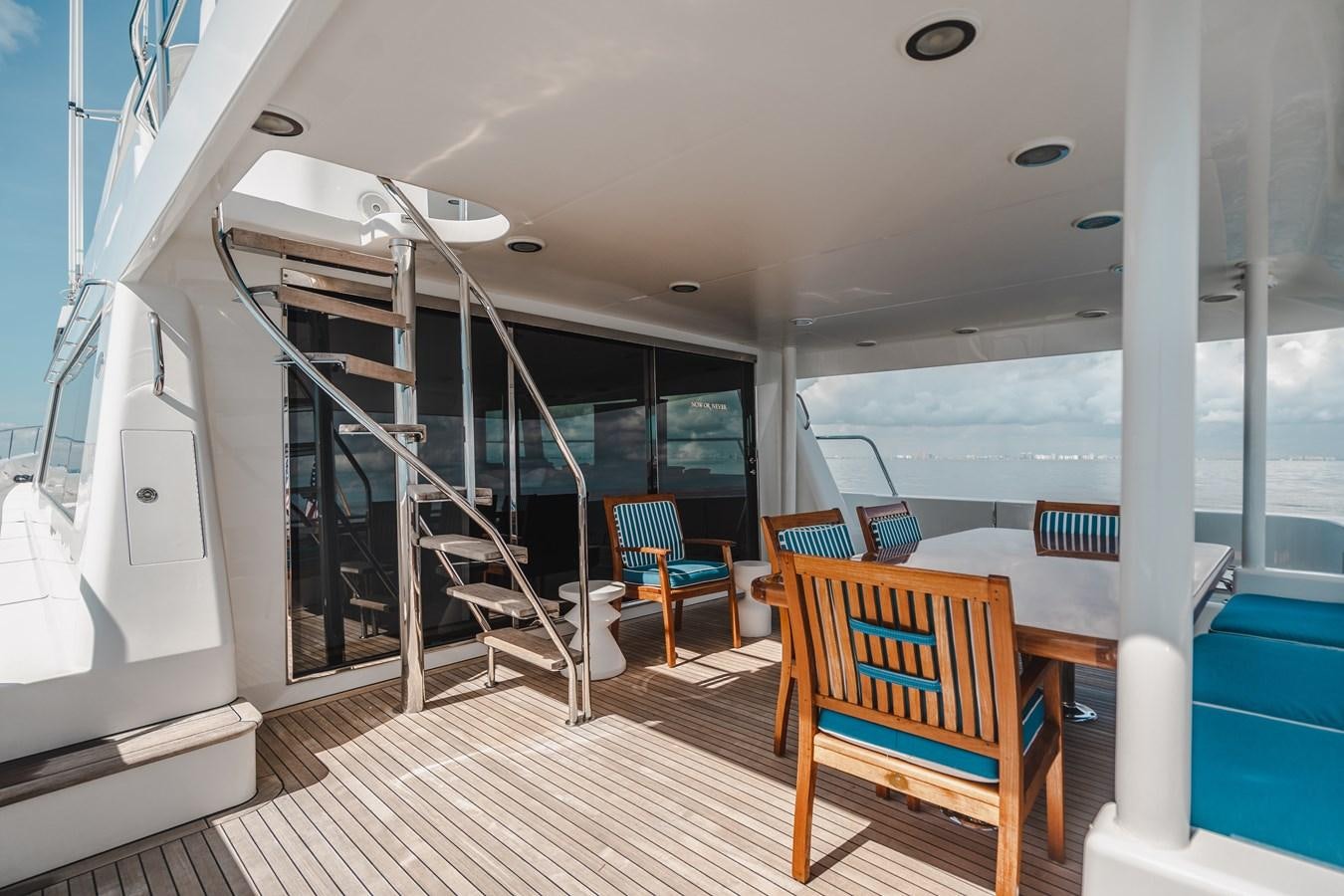 a room with a table chairs and a large glass window aboard NOW OR NEVER Yacht for Sale