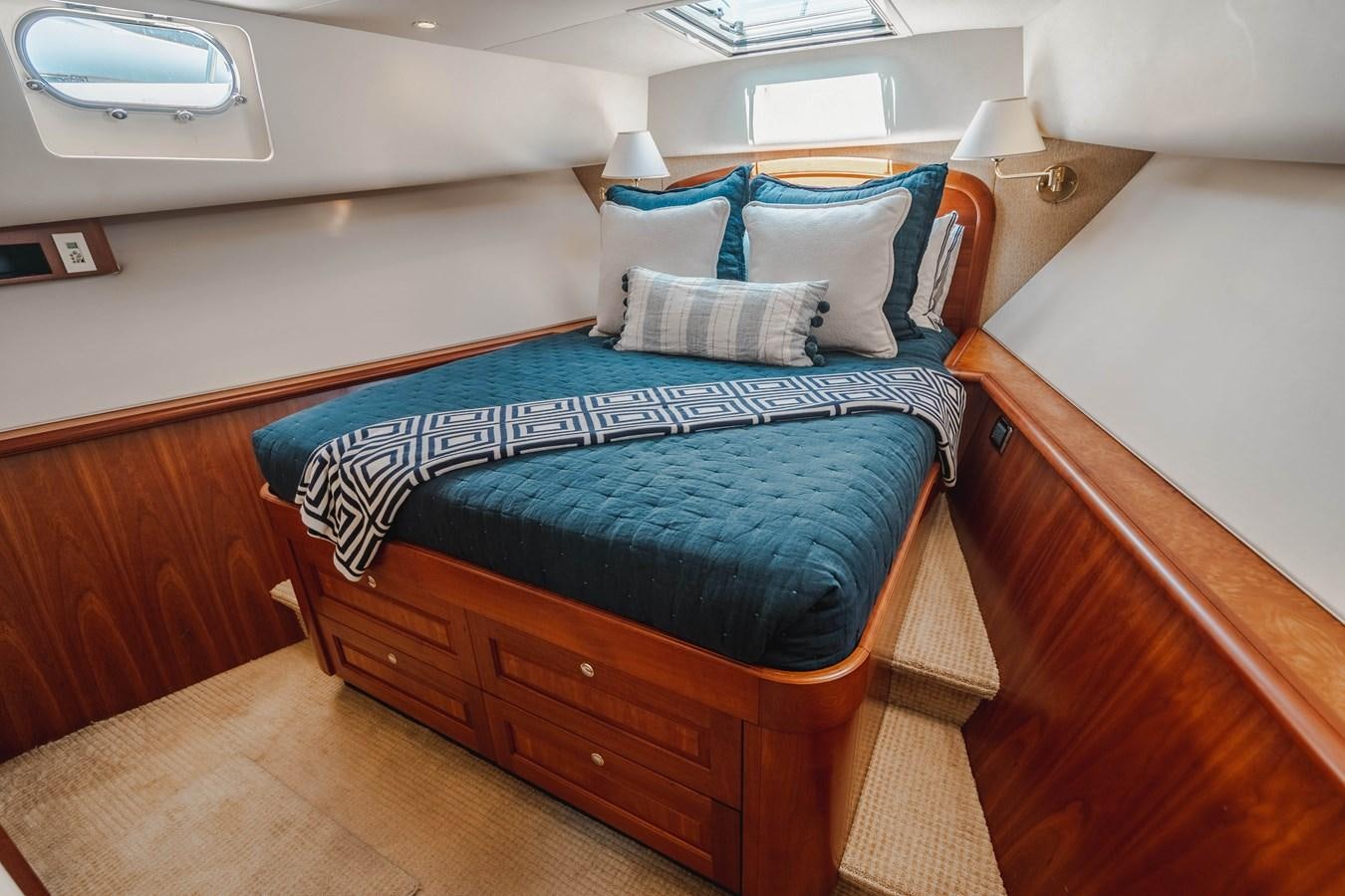 a bed with blue sheets aboard NOW OR NEVER Yacht for Sale