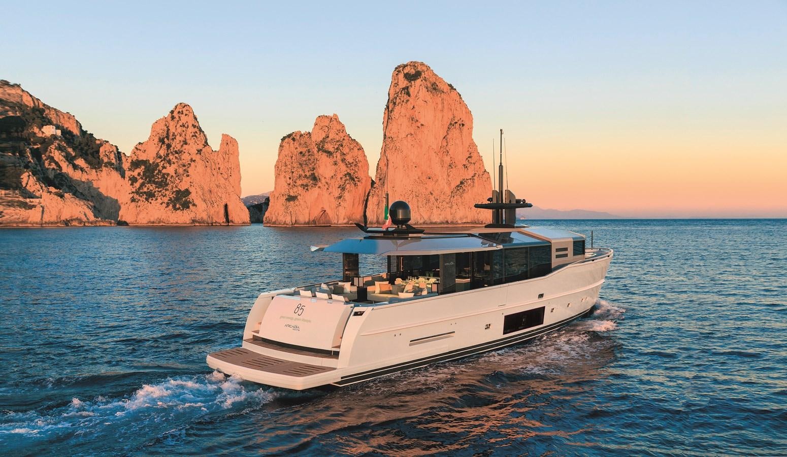 a boat in the water with a rock formation in the background aboard ARCADIA A85 Yacht for Sale