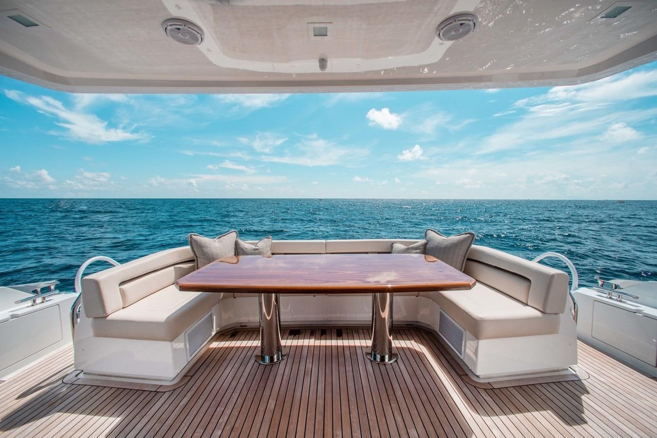 a table and chairs on a deck overlooking the ocean aboard NEW VIKING 82 COCKPIT MOTOR YACHT Yacht for Sale