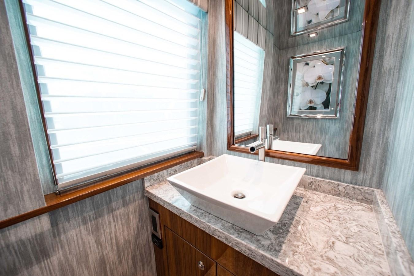 a bathroom with a mirror and a sink aboard NEW VIKING 82 COCKPIT MOTOR YACHT Yacht for Sale