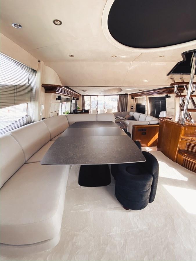 a living room with a table and couches aboard HELENA Yacht for Sale