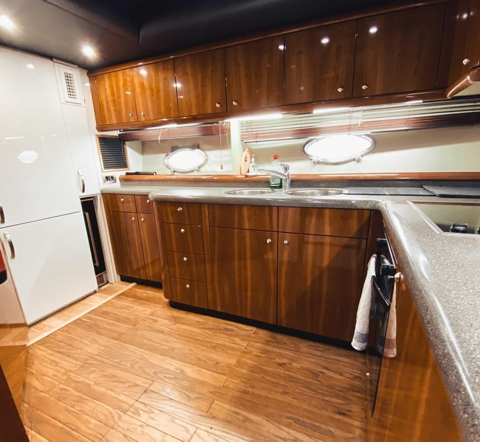 a kitchen with wooden cabinets aboard HELENA Yacht for Sale