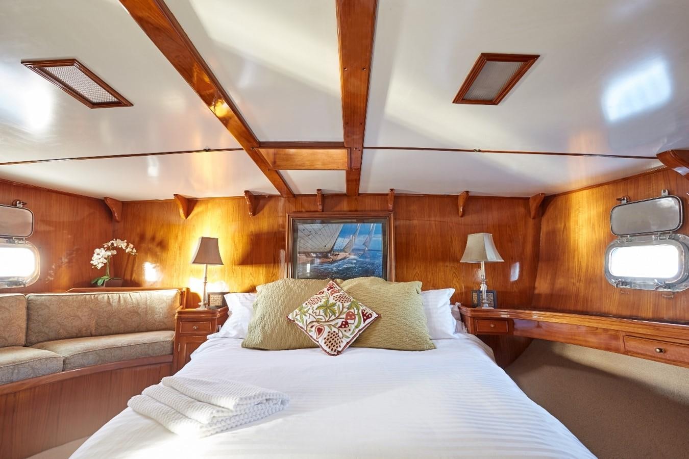 a bed with pillows and a couch aboard SLOW DANCE Yacht for Sale