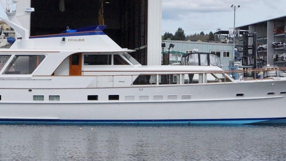 a white yacht in a harbor aboard EXCALIBUR Yacht for Sale