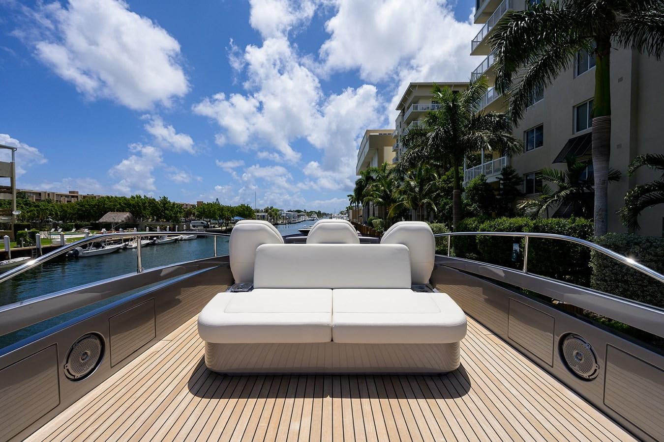 a lounge chair on a deck overlooking a pool and a large building aboard ON THE MOVE Yacht for Sale