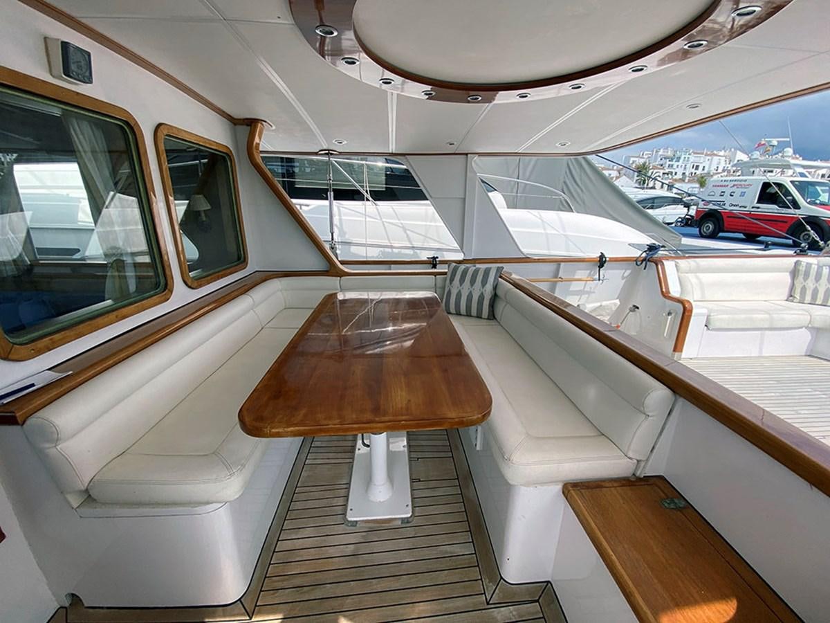 a room with a table and chairs aboard COLUMBUS OF LYMINGTON Yacht for Sale
