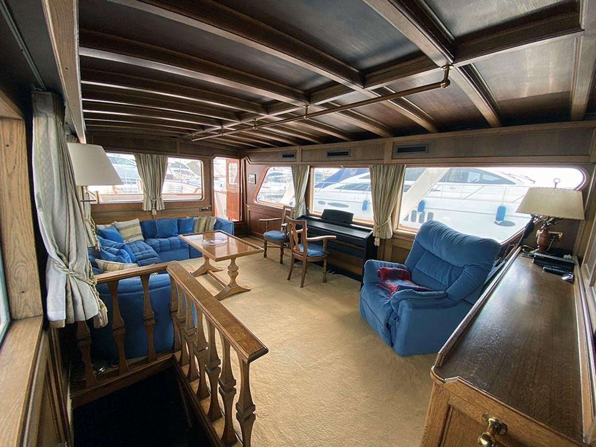 a room with a couch and a table and chairs aboard COLUMBUS OF LYMINGTON Yacht for Sale