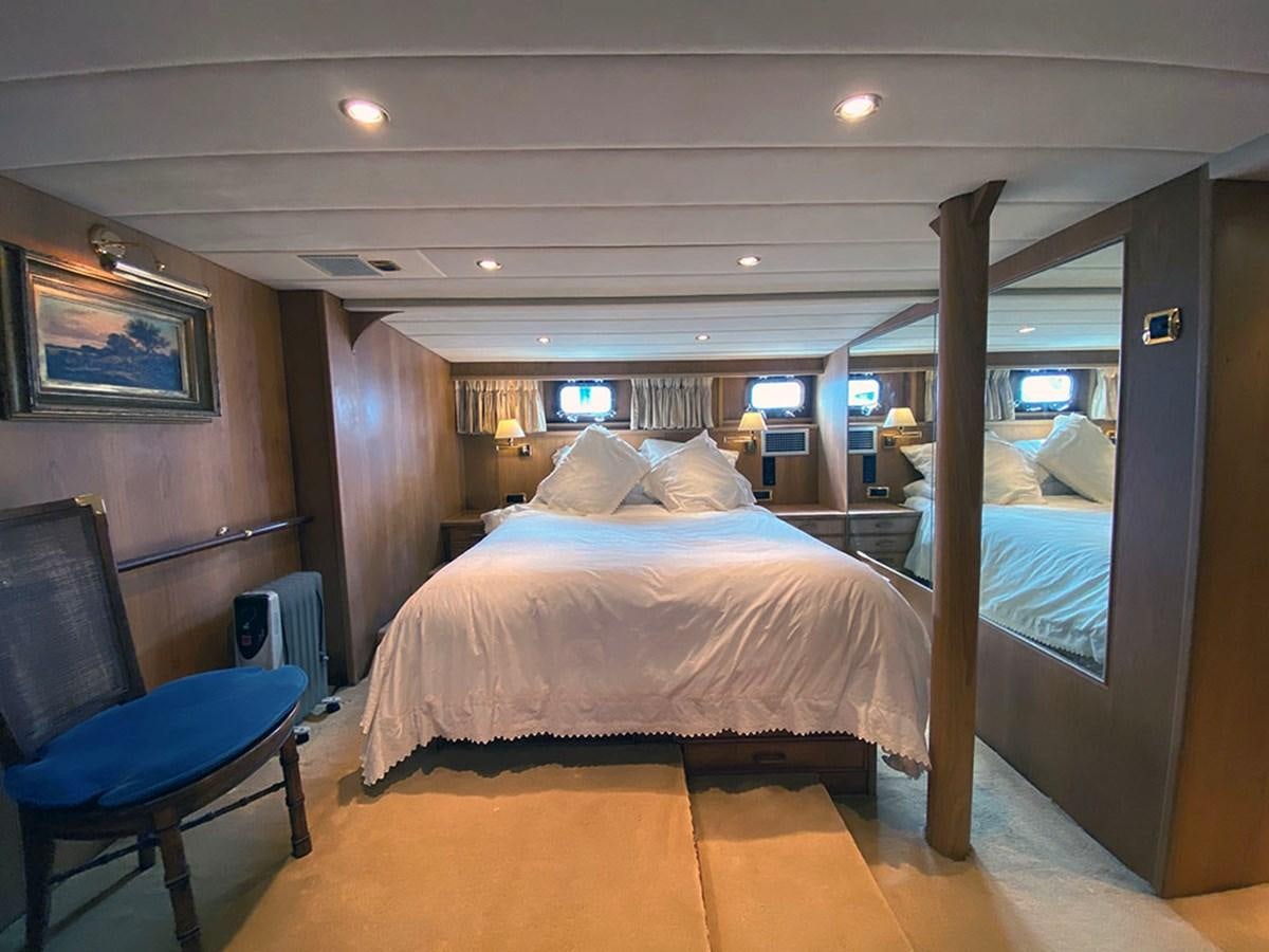 a bedroom with a bed and a chair aboard COLUMBUS OF LYMINGTON Yacht for Sale